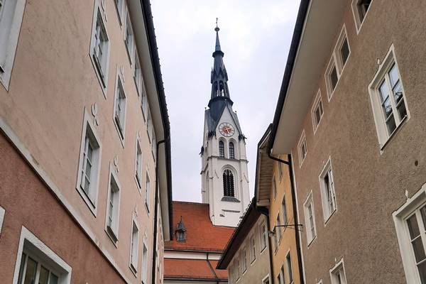 Blick auf eine Kirche zwischen Häusern.
