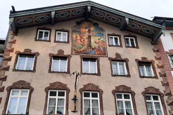 Jesus am Kreuz als Malerei auf Hausfront.