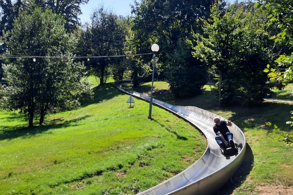 Ein Mann auf einer Sommerrodelbahn.